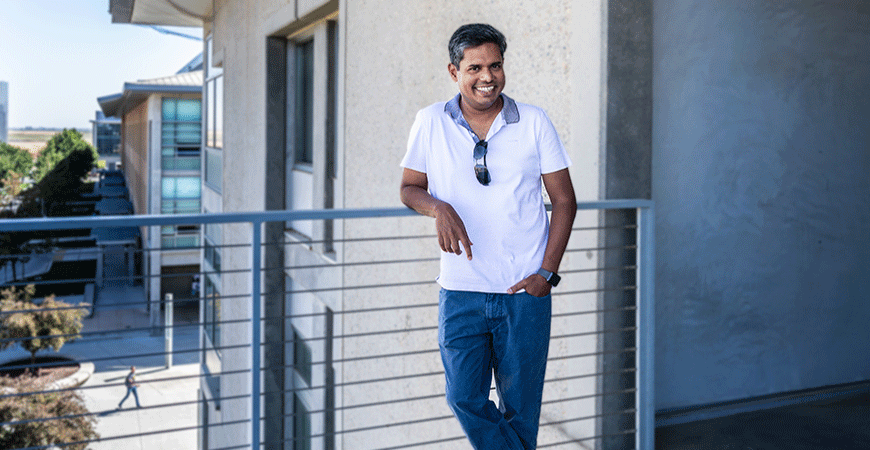 Professor Ajay Gopinathan leaning against outdoor railing