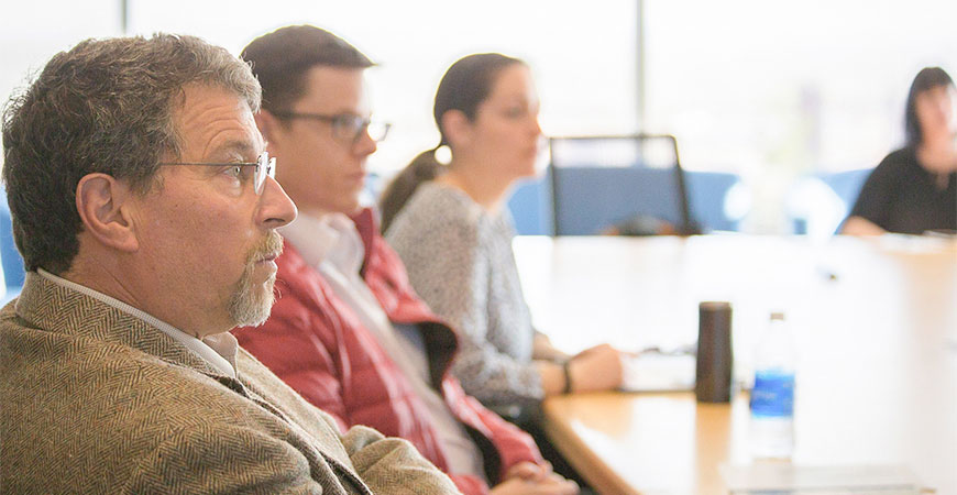 Faculty members sitting at table discussion for a mentorship workshop