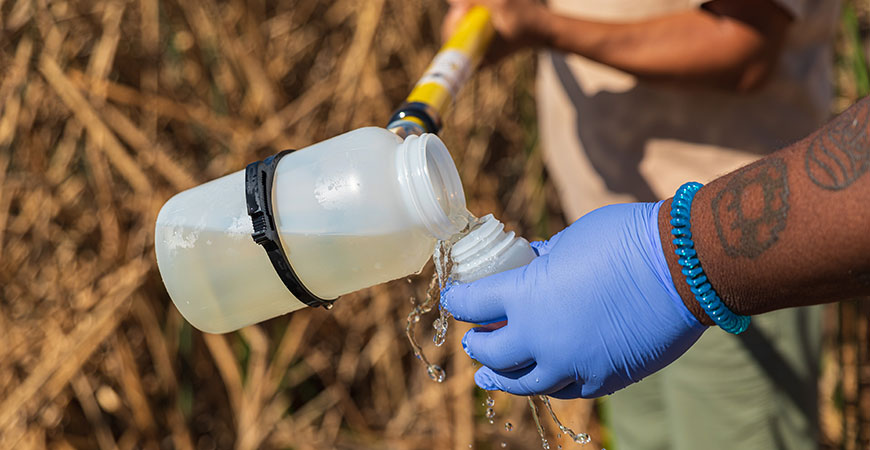 Student pouring water into a small bottle