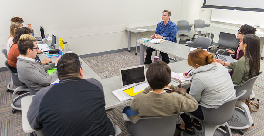 Professor Paul Almeida sitting in a round table discussion with students