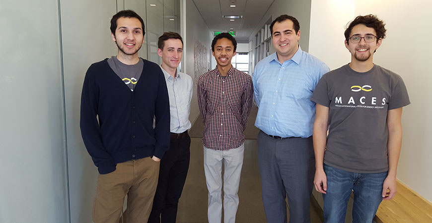 Five students posing in a hallway