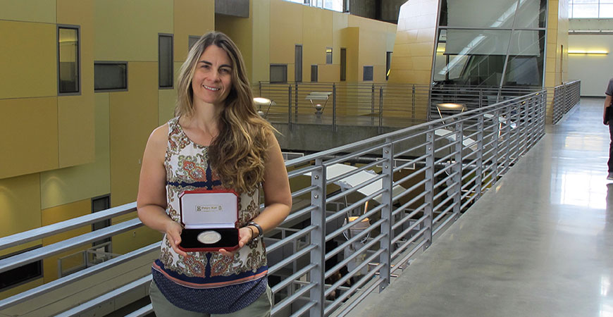 Professor Linda Hirst holding the Hilsum Medal