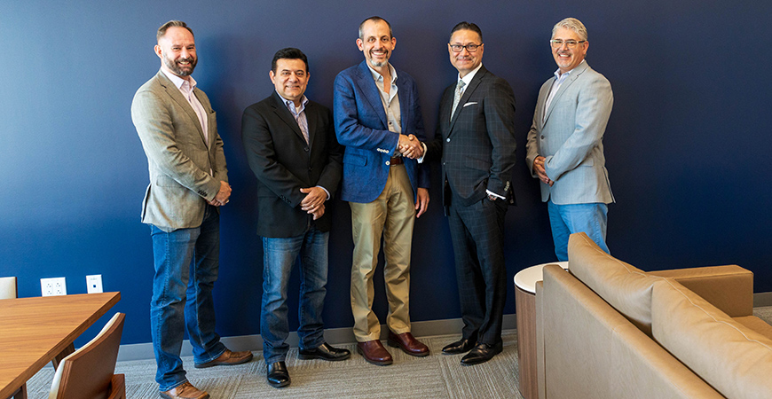 Five males standing in a conference room