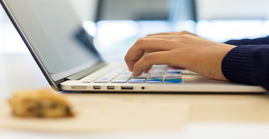 Fingers typing on a laptop