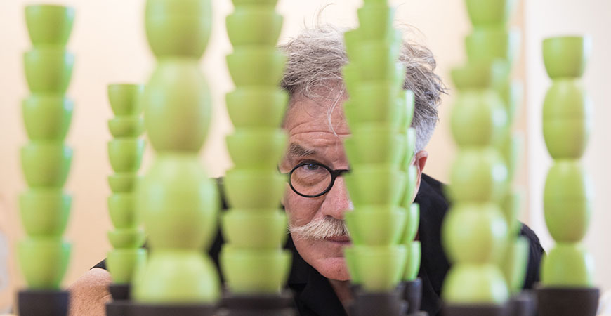 Focused view of Otto Rigan behind small green columns