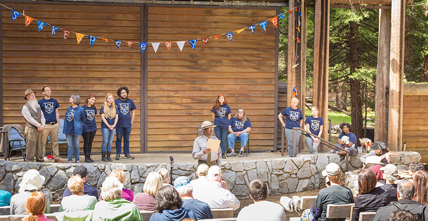 Park ranger speaking to a seated crowd in the park