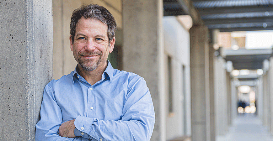 Professor David Ardell leaning against a wall