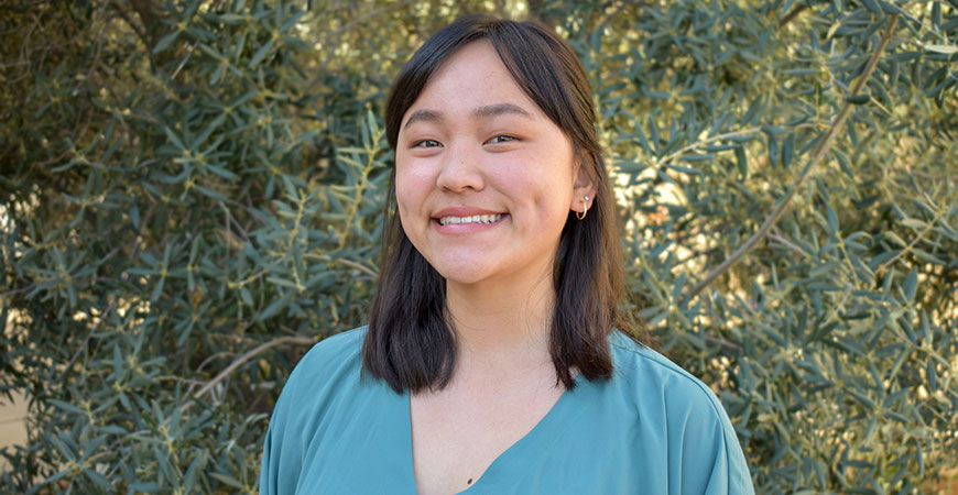 Calista Lum smiling in front of greenery