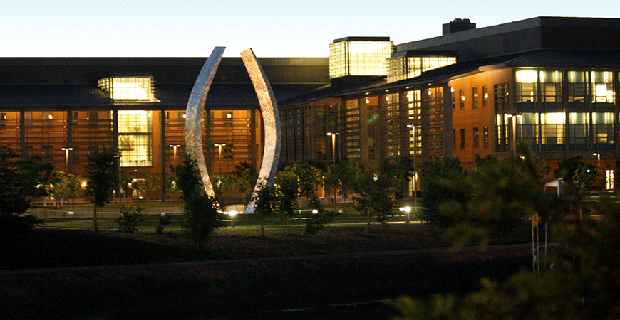 Evening view of Beginnings sculpture on campus quad