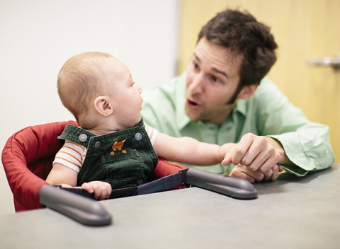 Professor Eric Walle interacts with an infant in the lab.